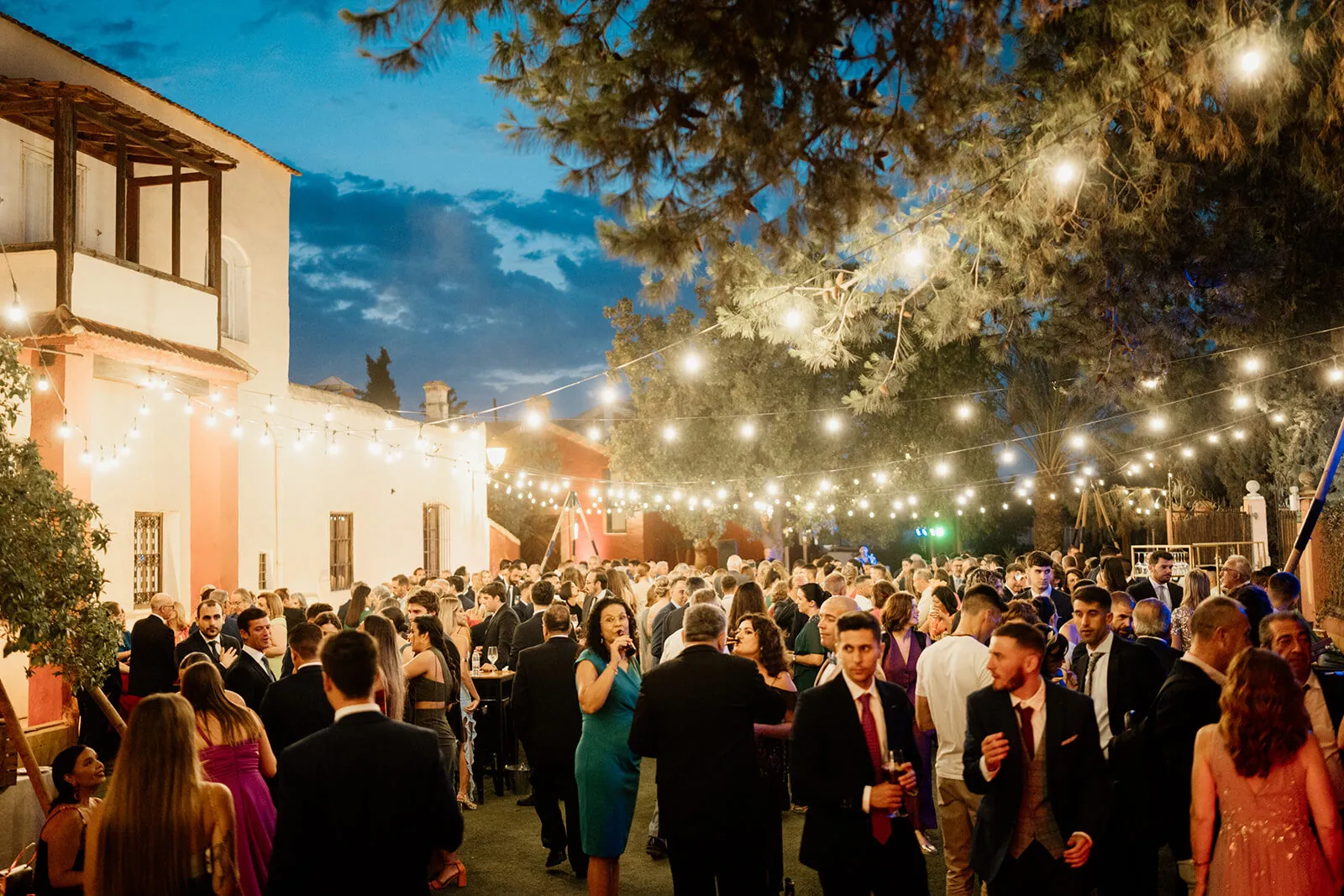Fiesta de boda al anochecer bajo un cielo de bombillas